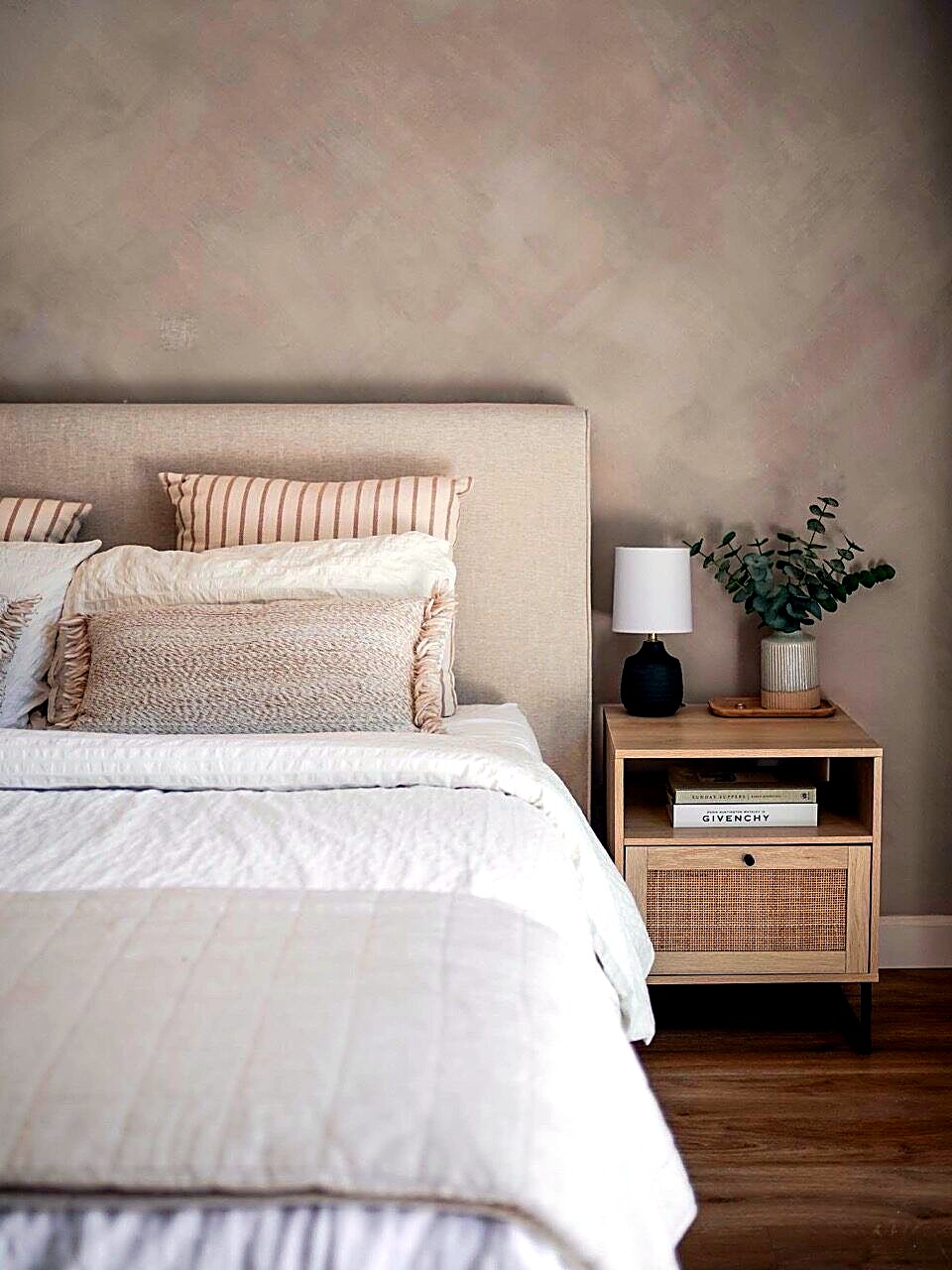 Bedroom with a calm neutral limewash wall behind the bed