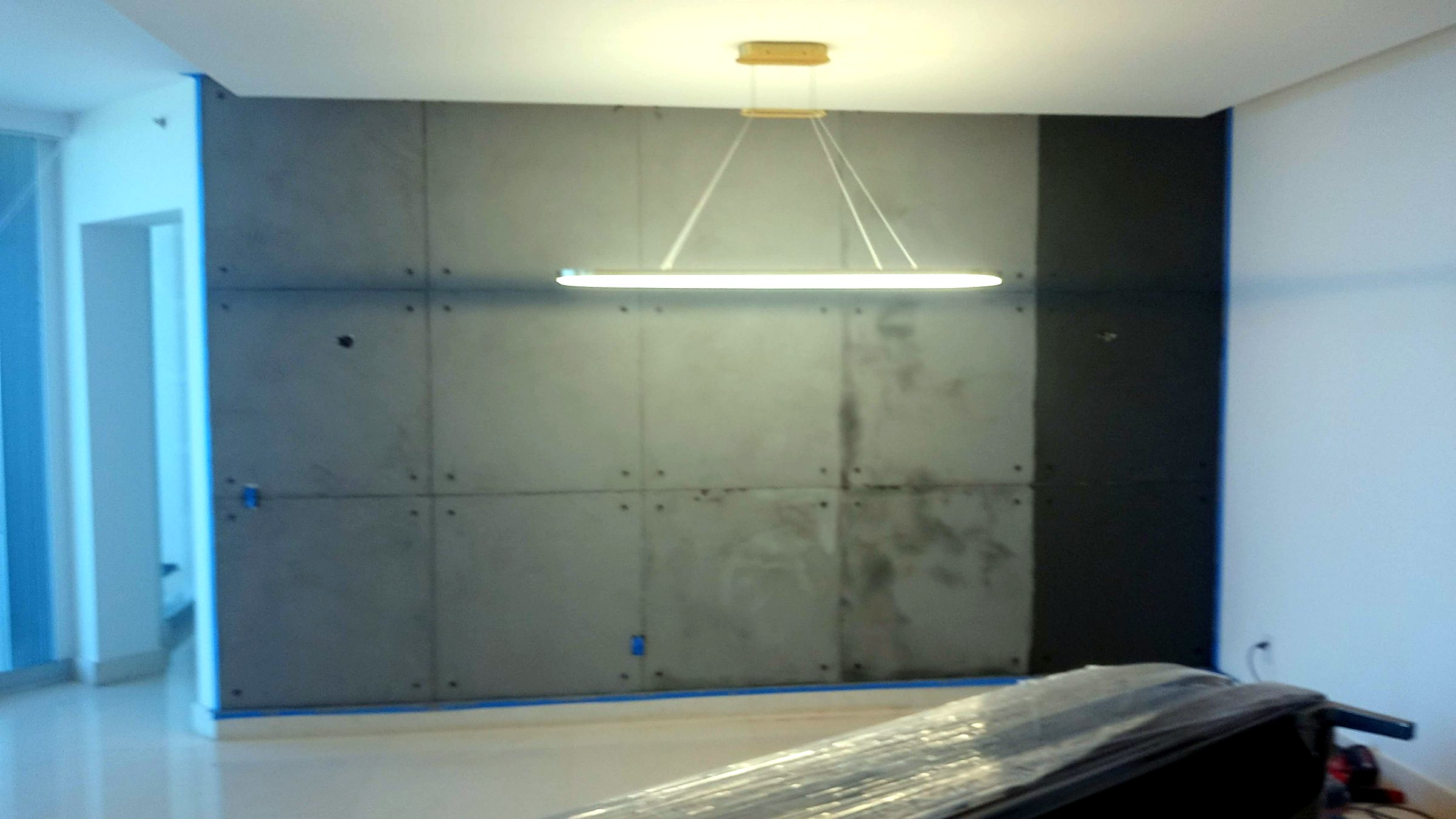 Dining room with microcement panels and a horizontal sculptural light