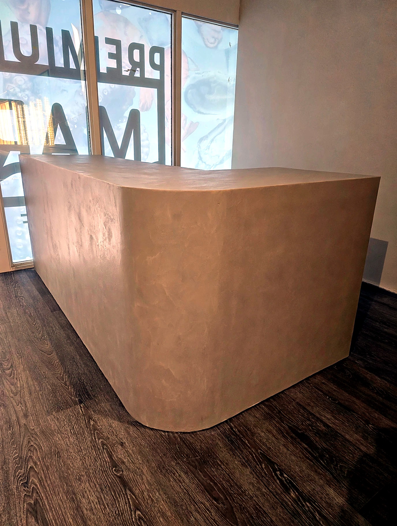 Sculptural reception counter finished in seamless microcement