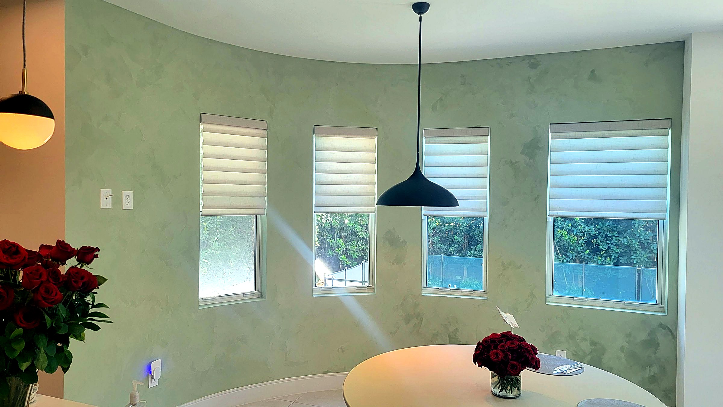 Dining room with a sage-toned Roman clay feature wall