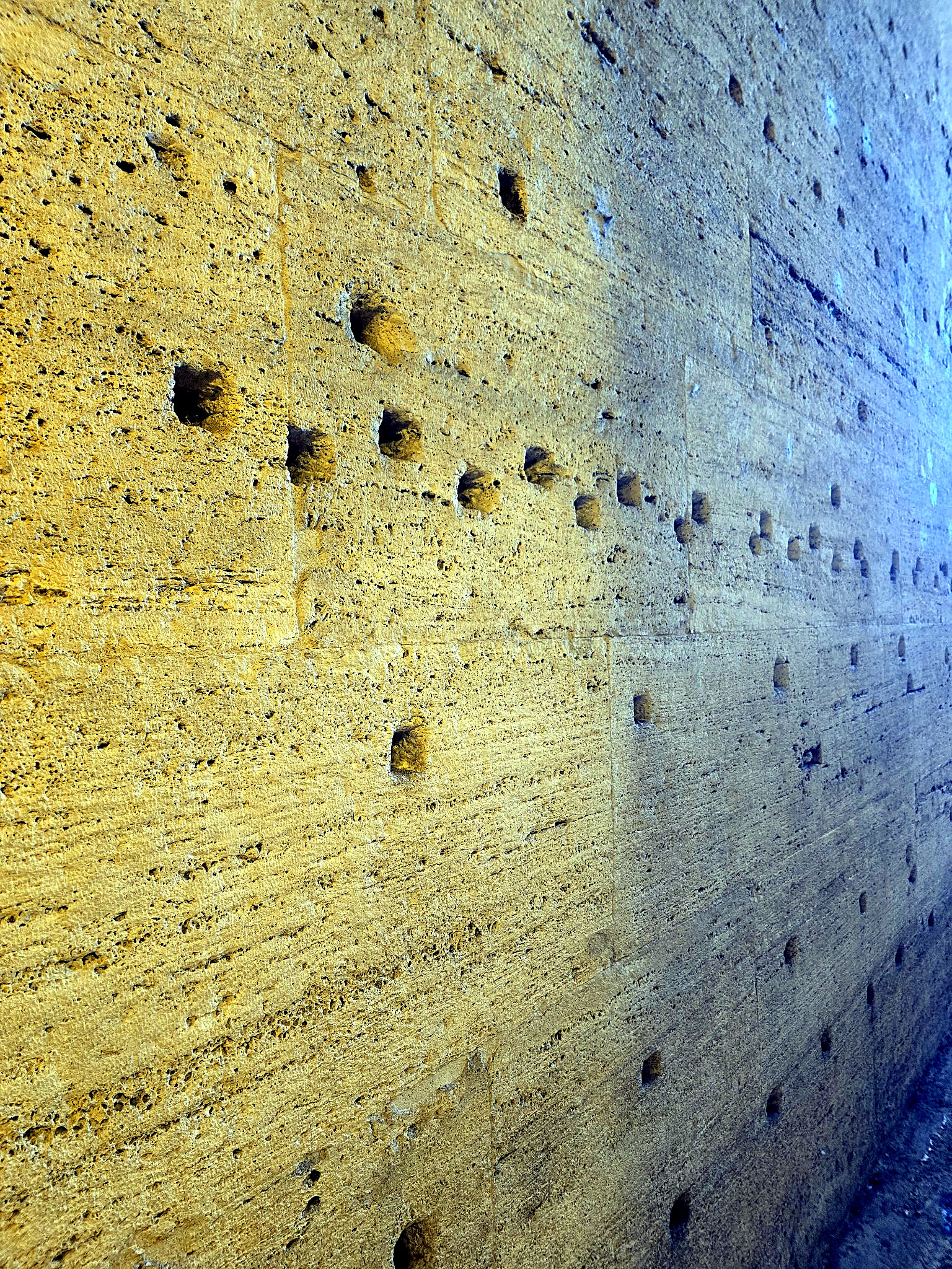 Close detail of a golden travertine wall with natural pitting