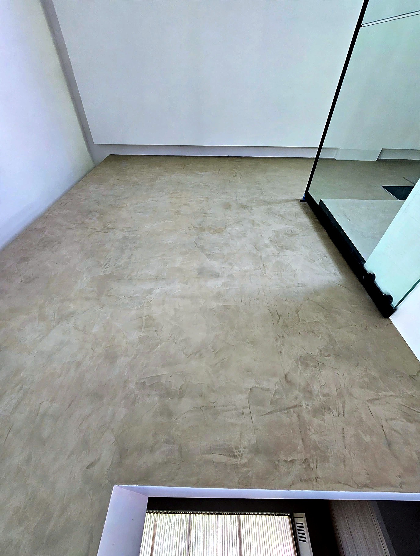 Roman clay finish on an upper staircase landing beside a glass balustrade