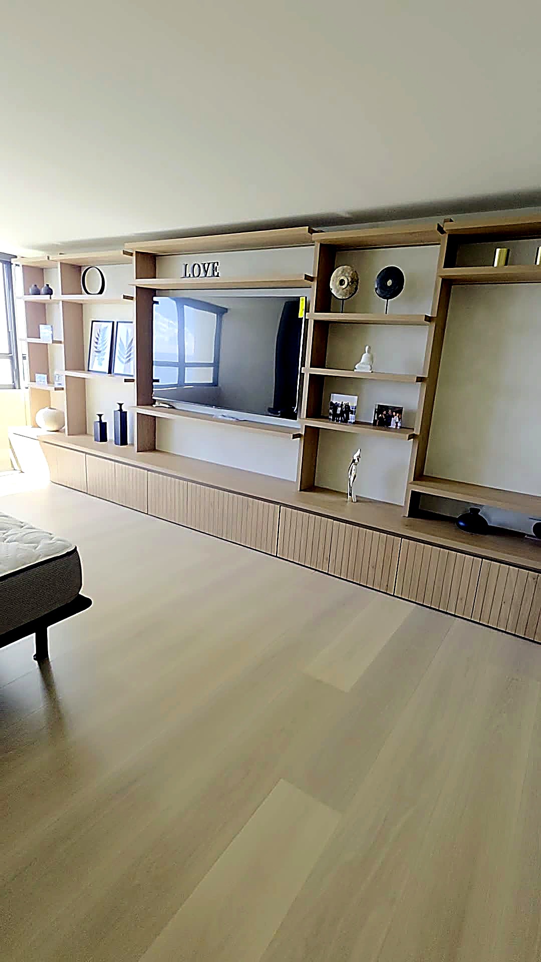 Primary bedroom with custom wood media wall and limewash finish
